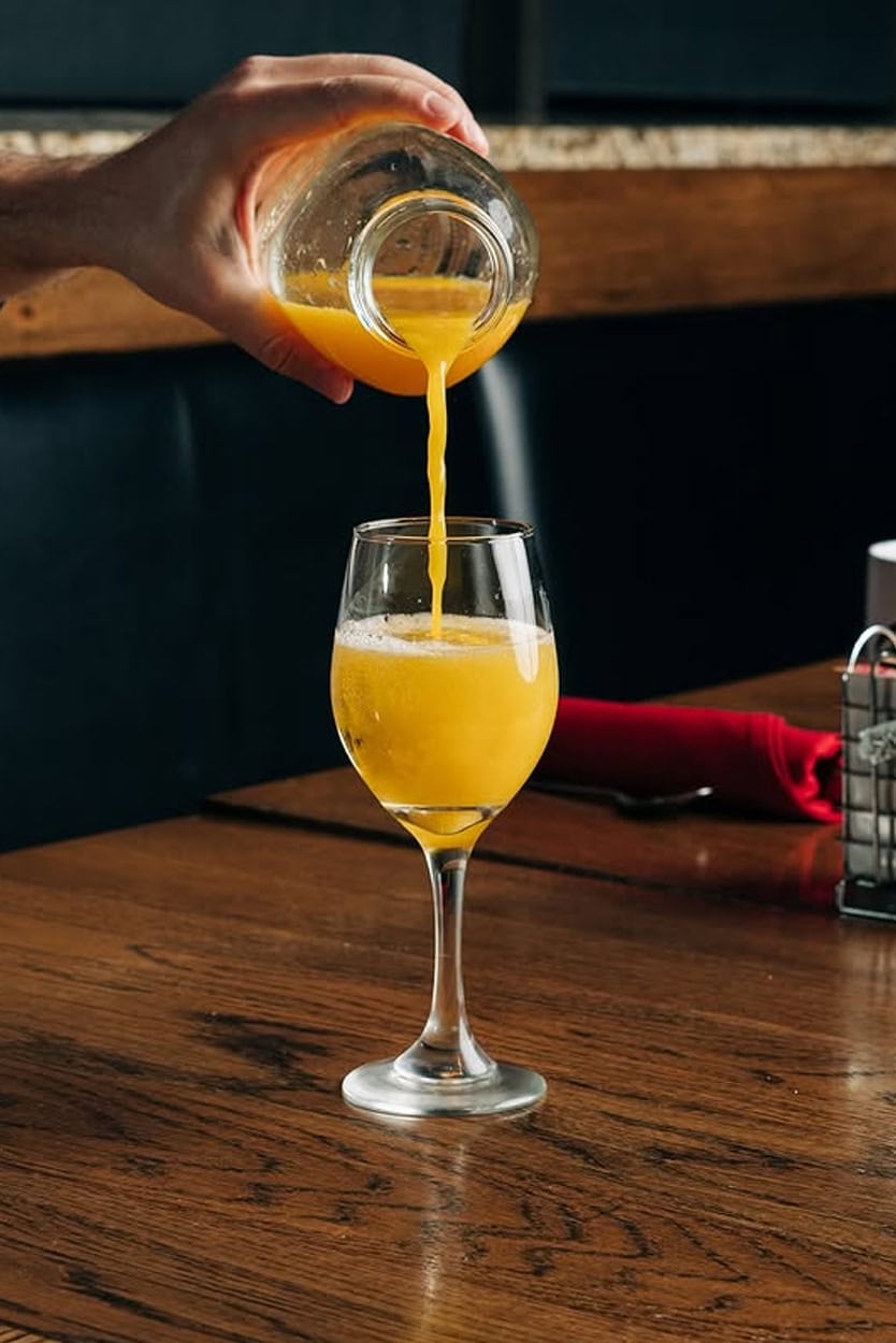Hand Pouring a Mimosa